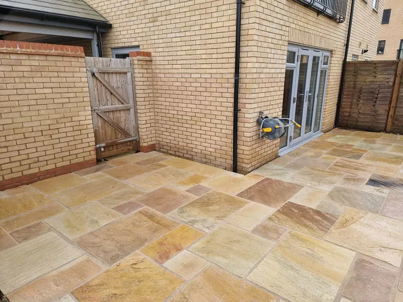A sandstone patio laid up to the back doors