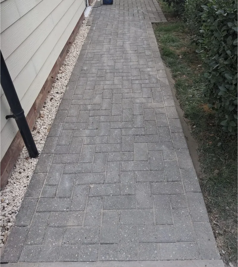 A block paved path finished alongside a house