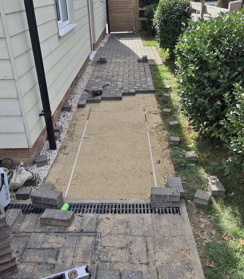 A block path lifted and relaid over a new drainage channel
